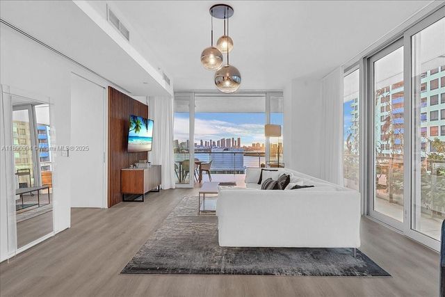 a living room with fireplace furniture and a large window