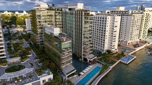a front view of a building with a garden and plants