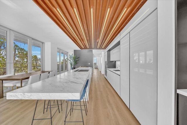 a dining room with furniture and a floor to ceiling window