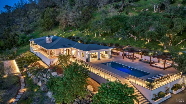 a kitchen with kitchen island a large counter top space appliances and a chandelier