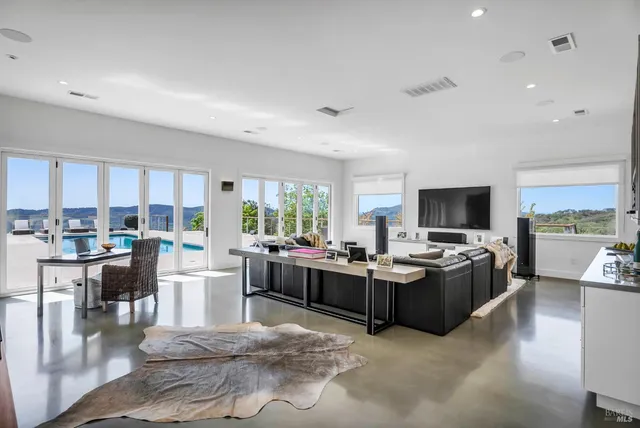 a living room with furniture a flat screen tv and large window