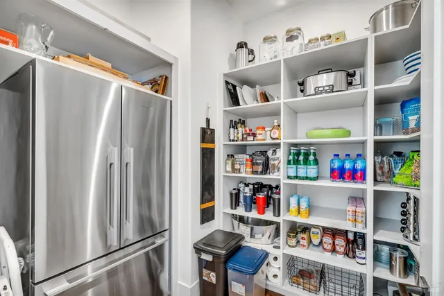 a view of a yard with plants and large trees