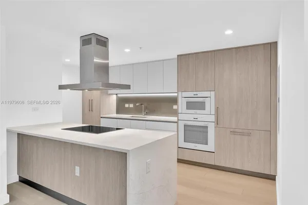 a kitchen with stainless steel appliances granite countertop a sink and a refrigerator