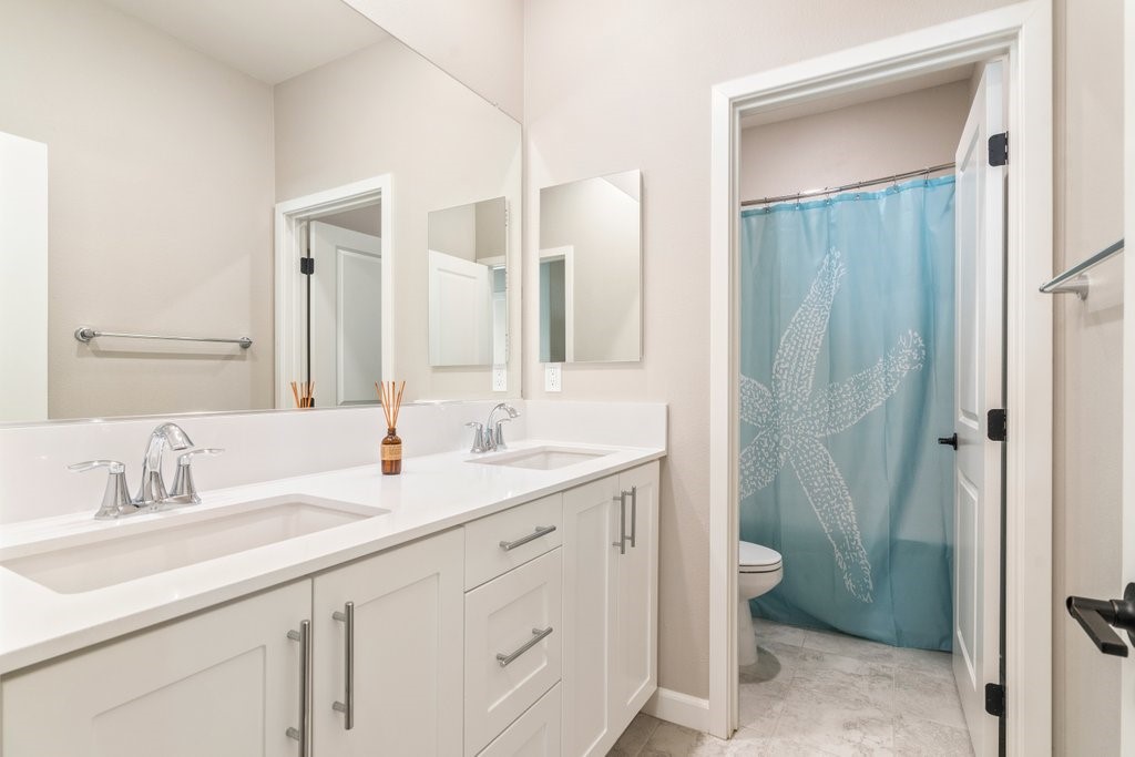 3573 Conner Way Oceanside, CA 92056 - Photo 17 of 25 a bathroom with a double vanity sink a toilet and a mirror