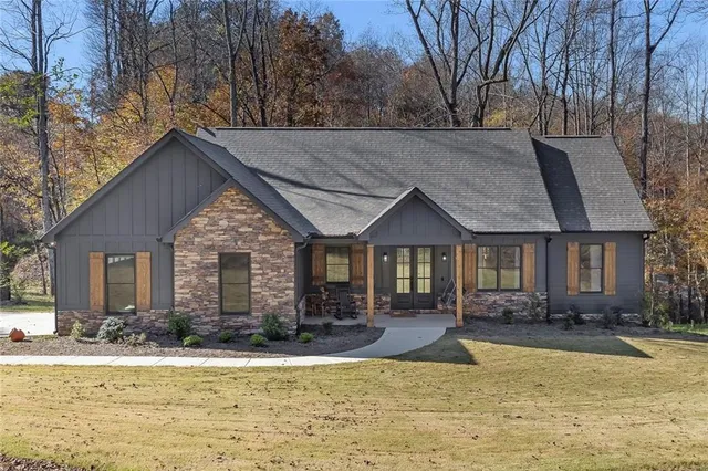 a front view of house with yard and trees around