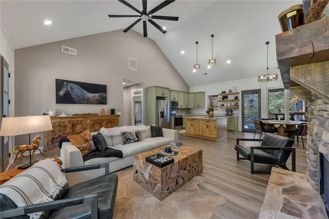 a living room with furniture kitchen view and a chandelier