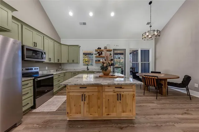 a open kitchen with stainless steel appliances granite countertop a stove and a refrigerator