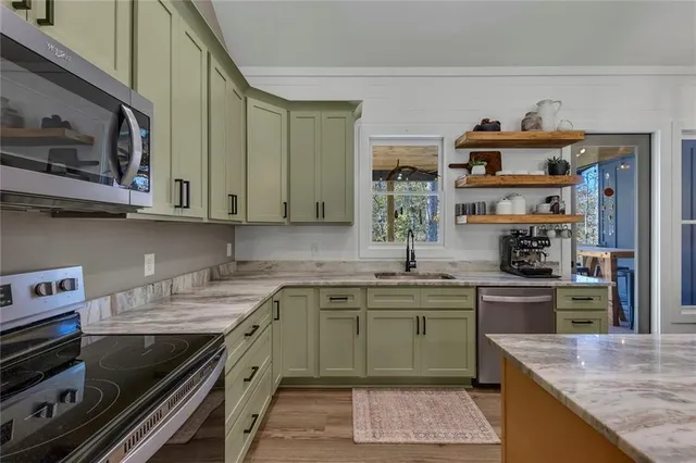 a kitchen with stainless steel appliances granite countertop a sink stove and cabinets