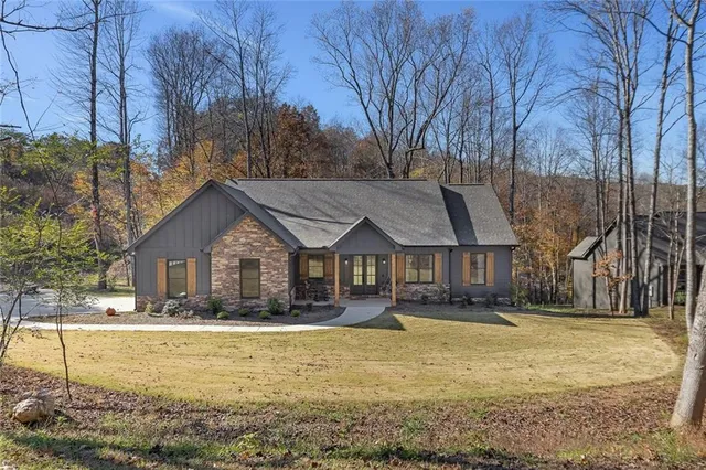 a front view of house with yard and trees in the background