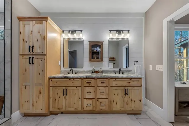 a bathroom with a double vanity sink mirror and shower