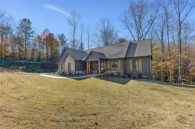 a front view of a house with yard and trees