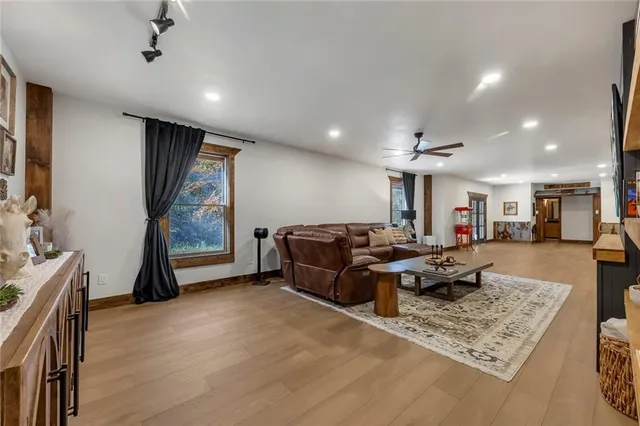 a living room with stainless steel appliances a fireplace and a television