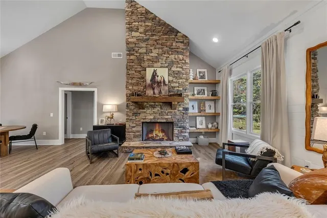 a living room with furniture large window and fireplace