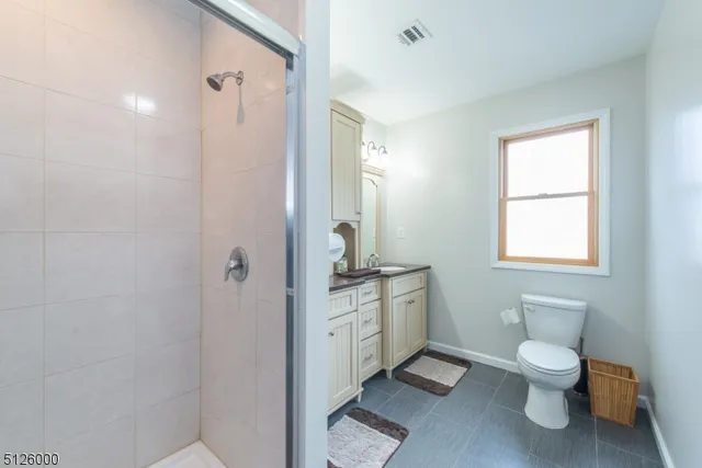 a bathroom with a granite countertop toilet a sink and a mirror