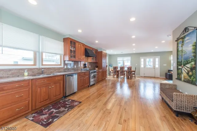 a kitchen with stainless steel appliances granite countertop wooden floors a stove and a sink