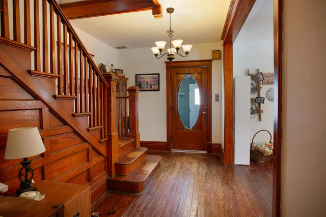 a view of a hallway with wooden floor and staircase