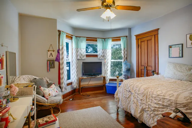 a bedroom with a bed and wooden floor