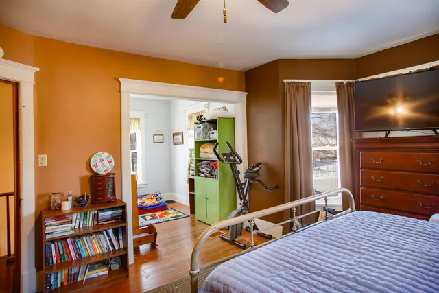 a bedroom with a bed and a flat tv screen on the dresser