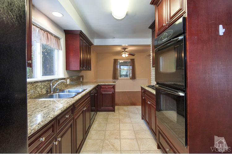 4739 Libbit Avenue Encino, CA 91436 - Photo 3 of 13 a large kitchen with granite countertop a sink and dishwasher a stove top oven with wooden floor