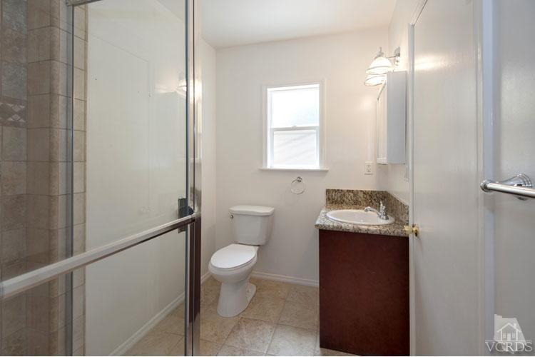 4739 Libbit Avenue Encino, CA 91436 - Photo 6 of 13 a bathroom with a granite countertop sink a toilet and a mirror