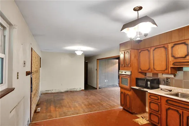 a room with stainless steel appliances kitchen island granite countertop a refrigerator and a stove top oven