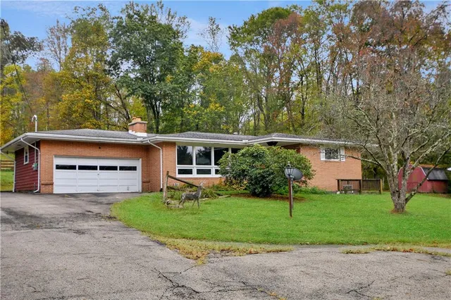 a front view of a house with a yard and trees