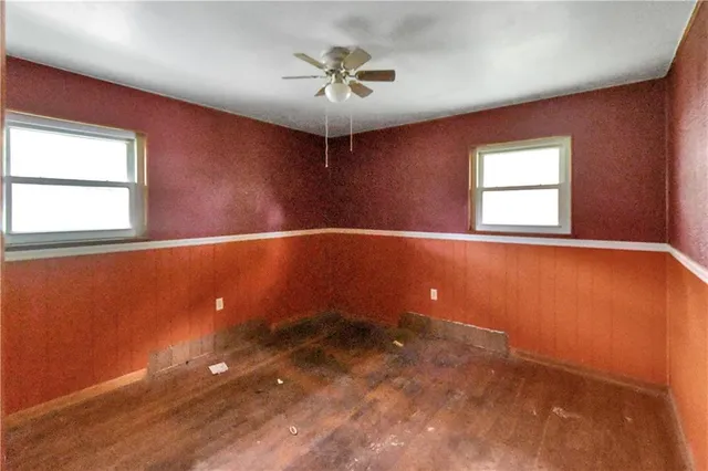 an empty room with a window and a ceiling fan