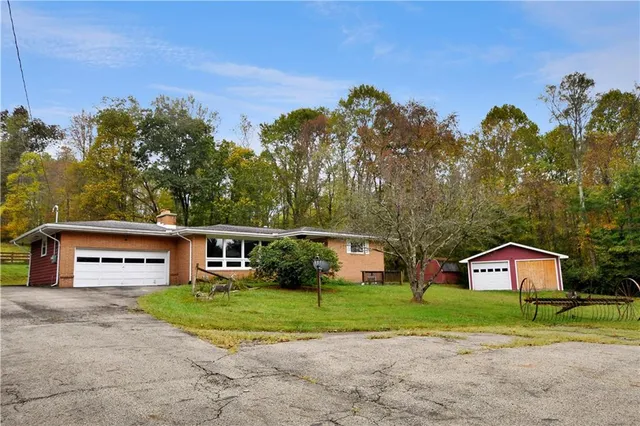 a front view of a house with a yard and trees