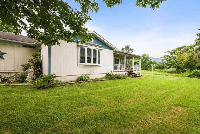 an aerial view of residential houses with outdoor space and lake view