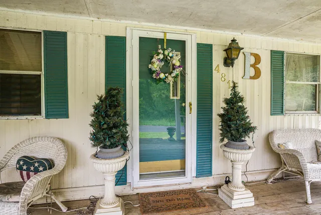 a view of a porch with chairs and potted plants