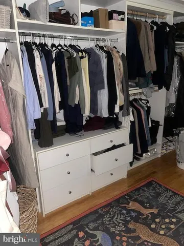 a view of walk in closet with clothes and shoes