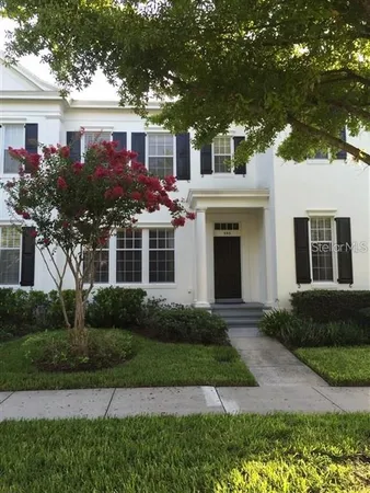 a front view of a house with garden and trees