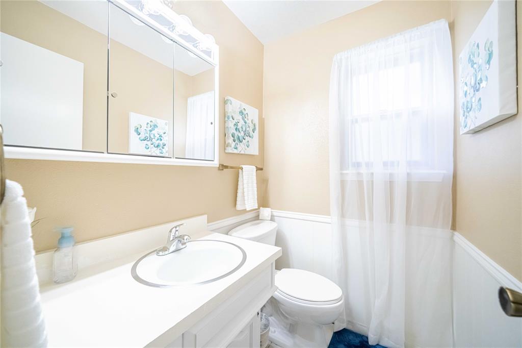 919 Green Hills Road Duncanville, TX 75137 - Photo 13 of 37 Full bath with wainscoting, toilet, and vanity