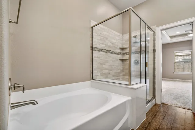 a bathroom with a double vanity sink a large mirror and a bathtub