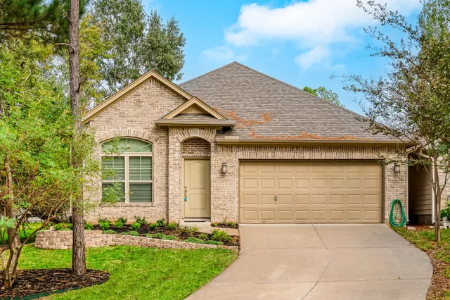a front view of a house with a garden and yard