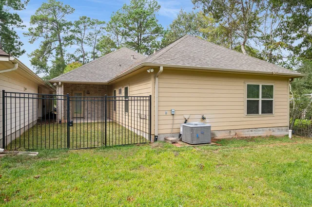 a view of a backyard with plants and large tree