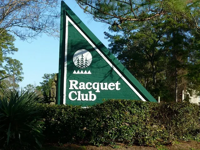 a sign that is on a wooden wall under a large tree