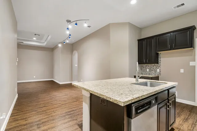 a kitchen with stainless steel appliances granite countertop a sink stove microwave and refrigerator