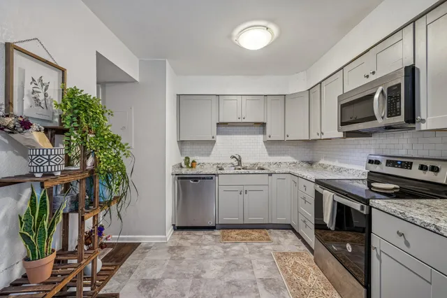 a kitchen with stainless steel appliances granite countertop a refrigerator and a stove top oven