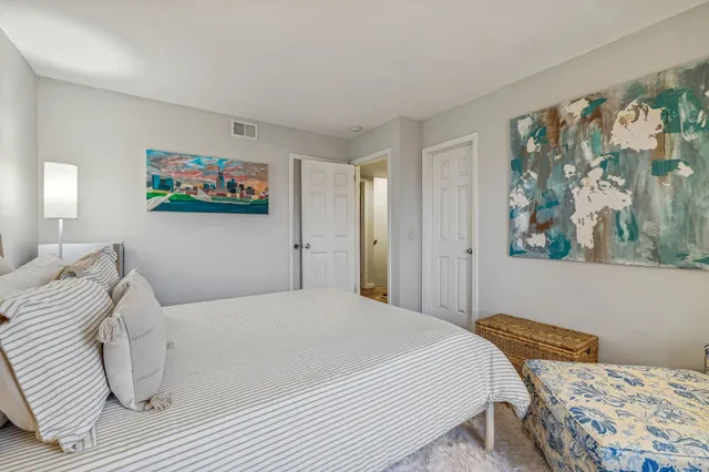 a bedroom with a bed and a painting on the wall