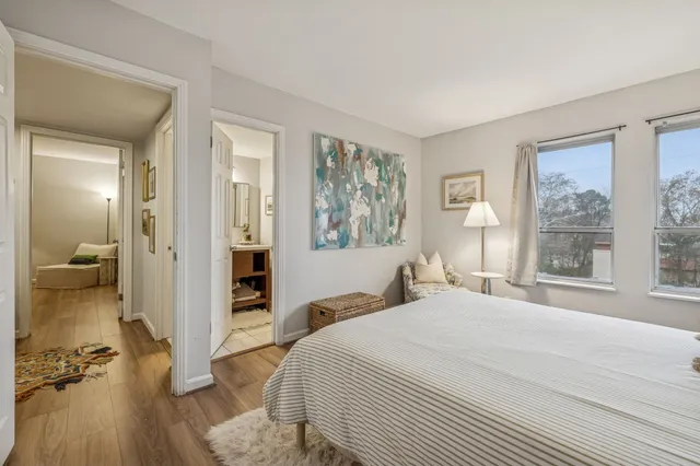 a bedroom with a balcony a bed and a large window