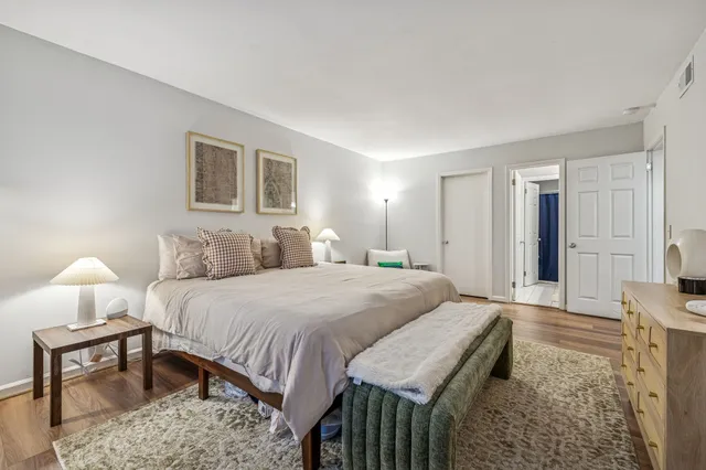 a spacious bedroom with a bed and a lamp