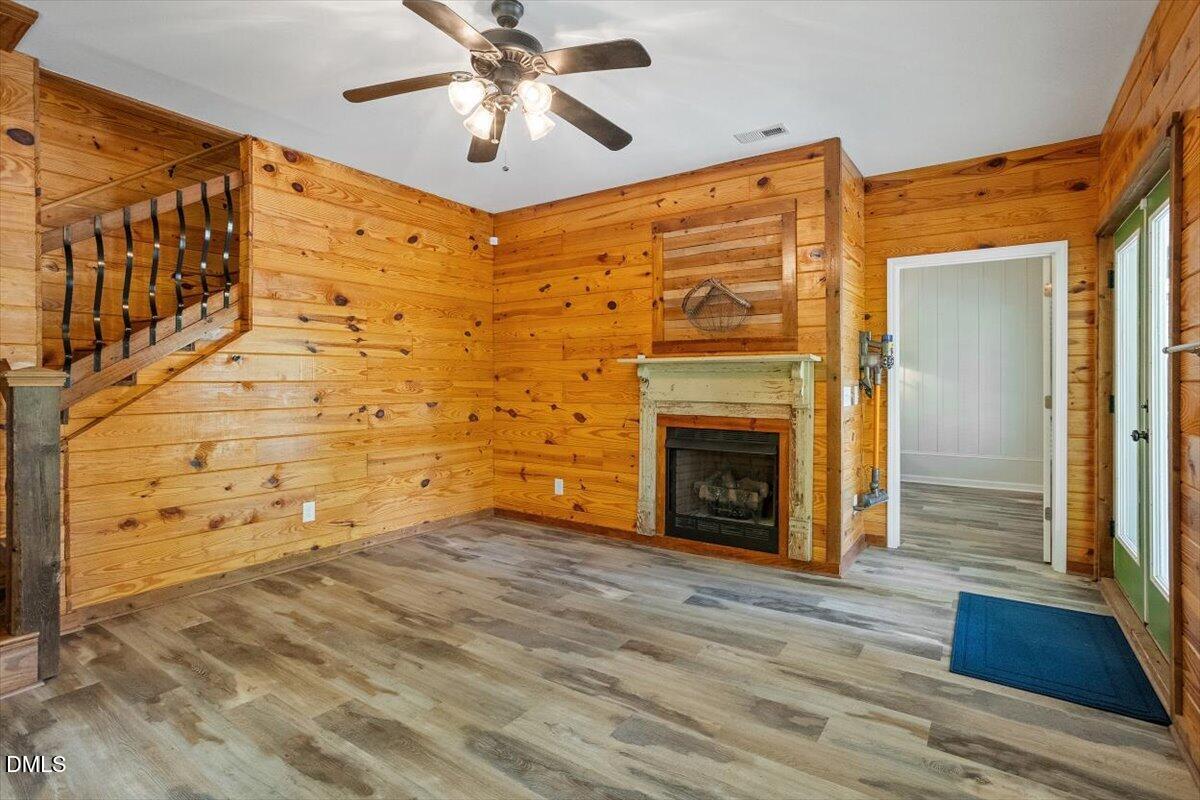 160 Stillwater Lane Roxboro, NC 27574 - Photo 25 of 57 a view of a livingroom with wooden floor a ceiling fan and a fireplace