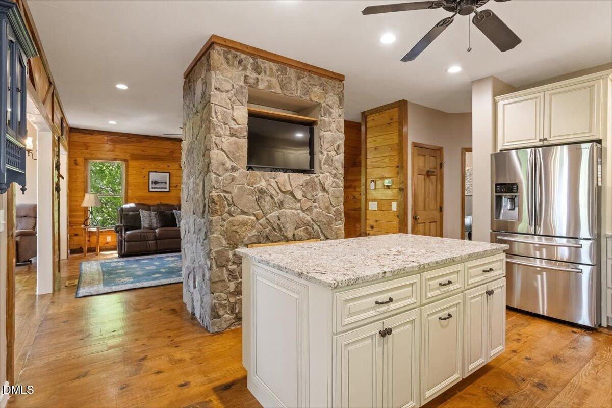 160 Stillwater Lane Roxboro, NC 27574 - Photo 7 of 57 a kitchen with stainless steel appliances kitchen island granite countertop a refrigerator a stove and a sink with wooden floor