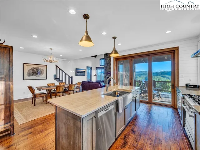 a kitchen with a table chairs stove and wooden floor