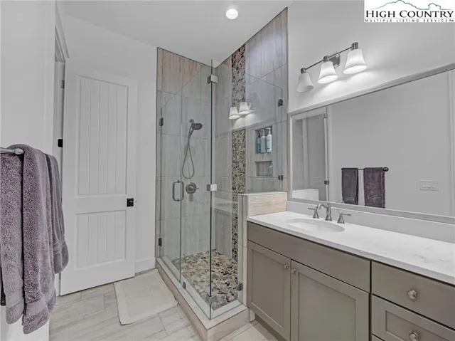 a bathroom with a shower sink and mirror