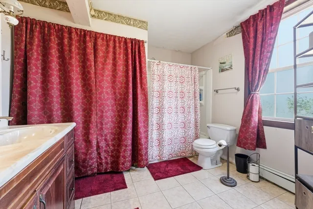 a bathroom with a sink a toilet and shower curtain