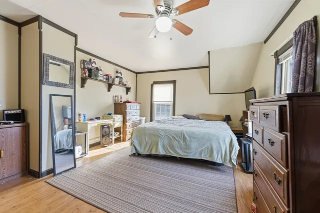 a bedroom with a bed and wooden floor