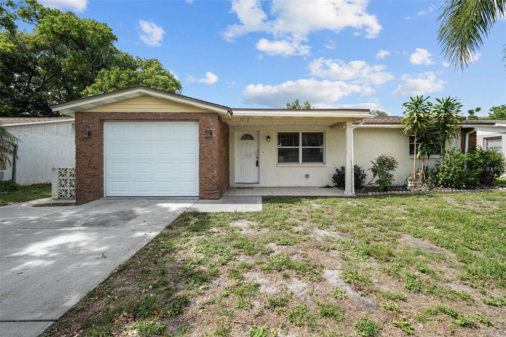 7115 Oakshire Drive Port Richey, FL 34668 - Photo 1 of 1 a front view of a house with garden