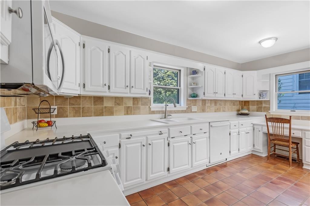 449 Nelson Ferry Road Decatur, GA 30030 - Photo 9 of 29 a kitchen with white cabinets a sink and white appliances